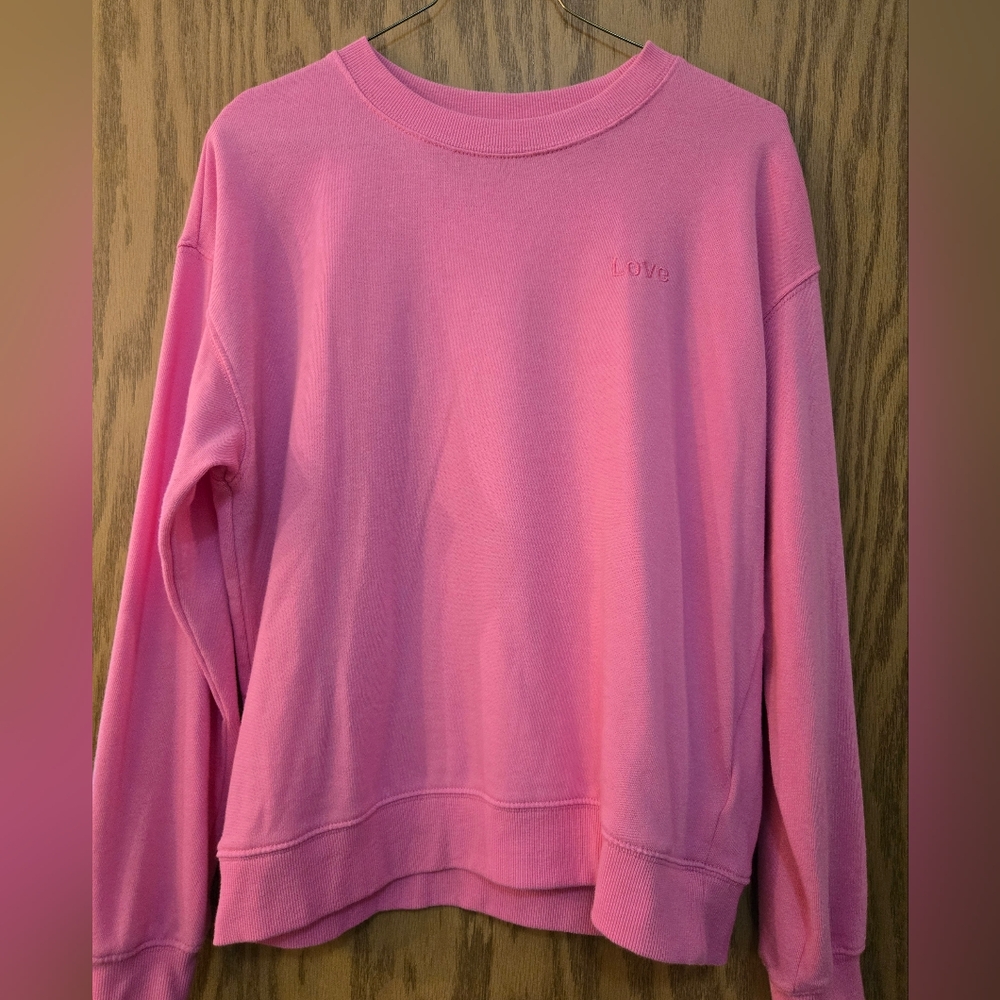 Pretty pink long sleeve sweat shirt with "love" on the upper right side.